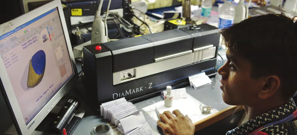 Gemologist running diamonds through a laboratory screening instrument