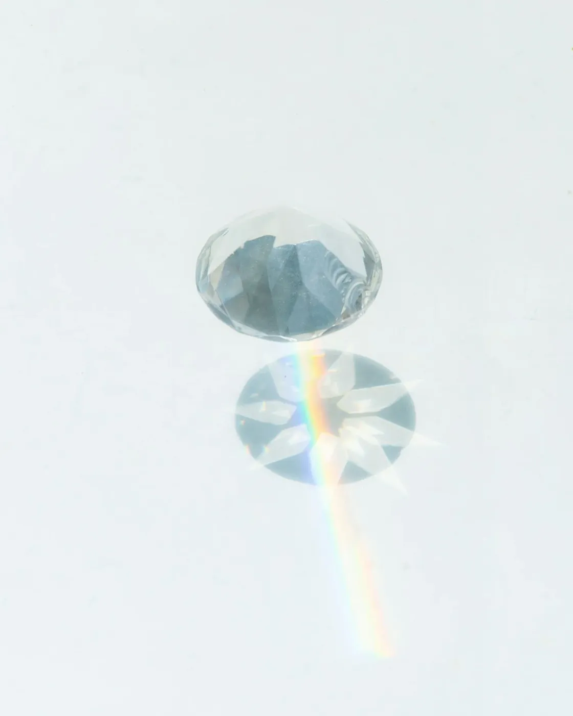 Clear lab-grown diamond with rainbow light reflection showing brilliance and facets.