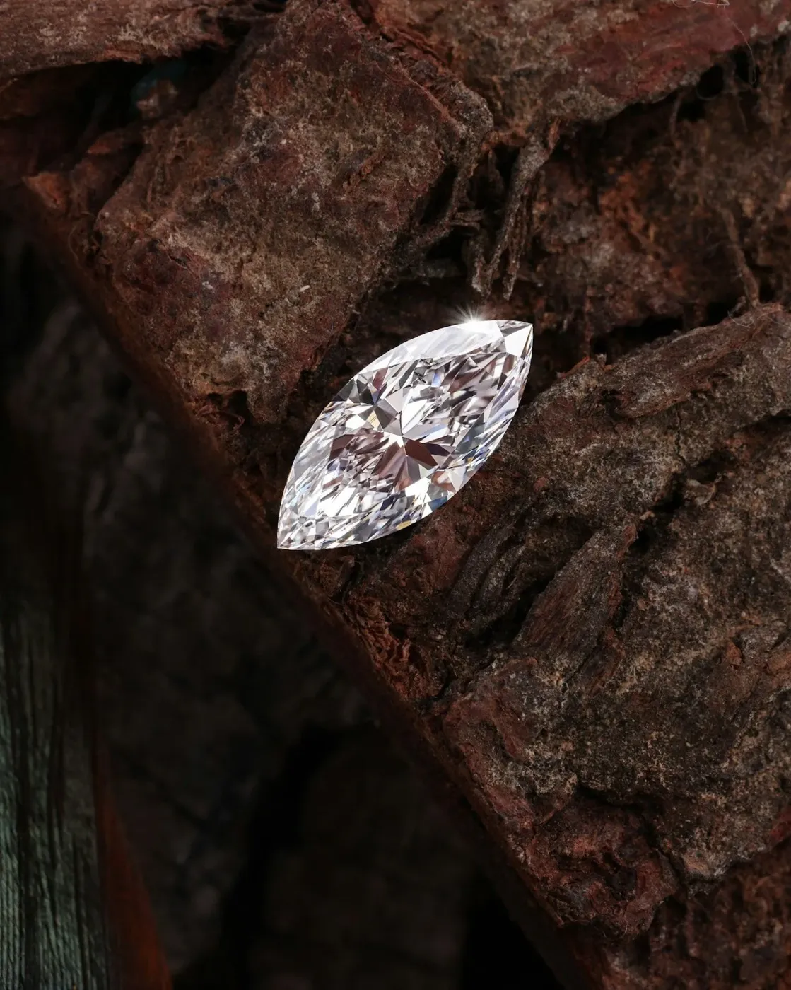 Marquise-cut natural diamond on rough stone surface symbolizing rarity and earth origin.