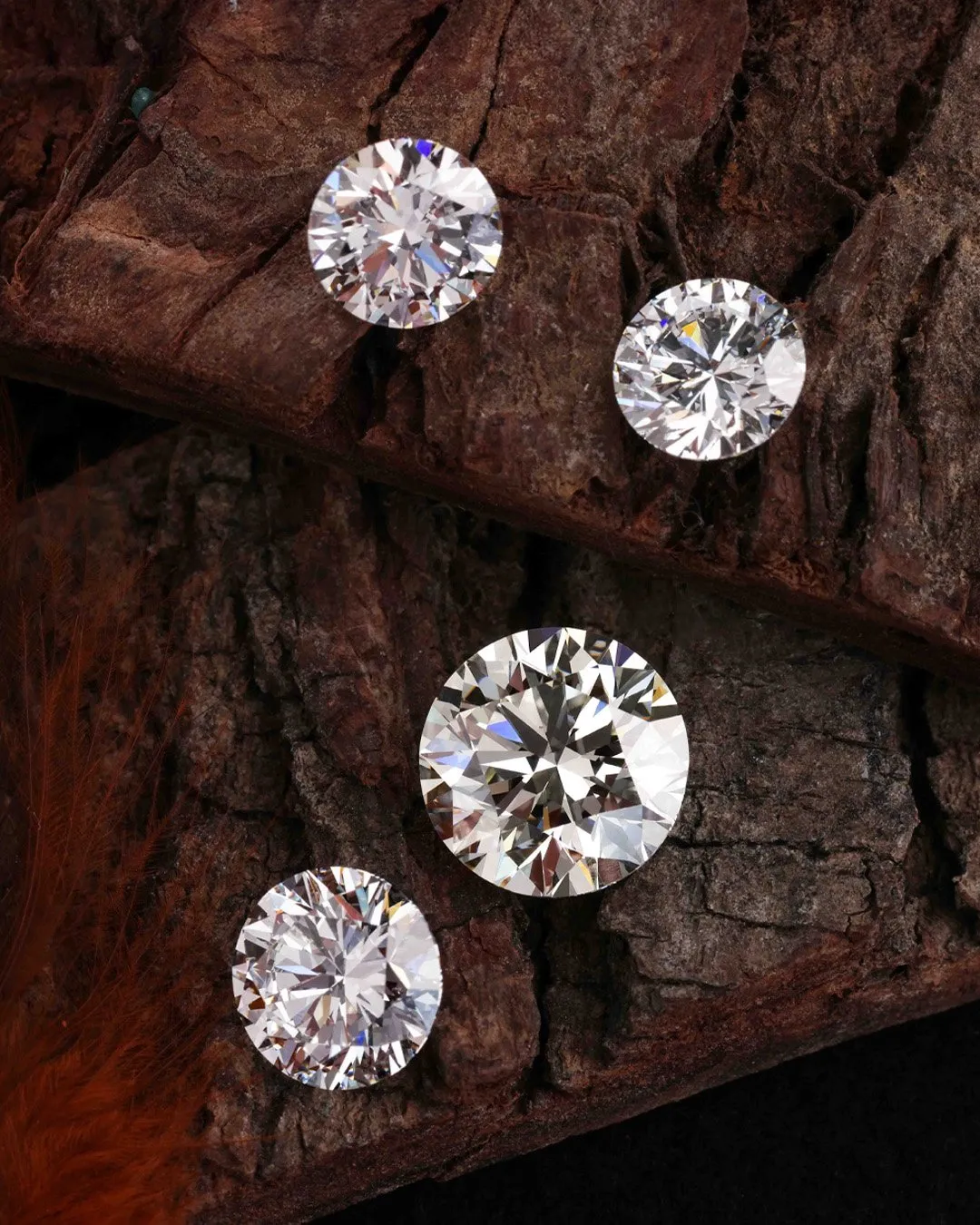 Four round-cut natural diamonds on rough wood surface symbolizing timeless heirloom value.